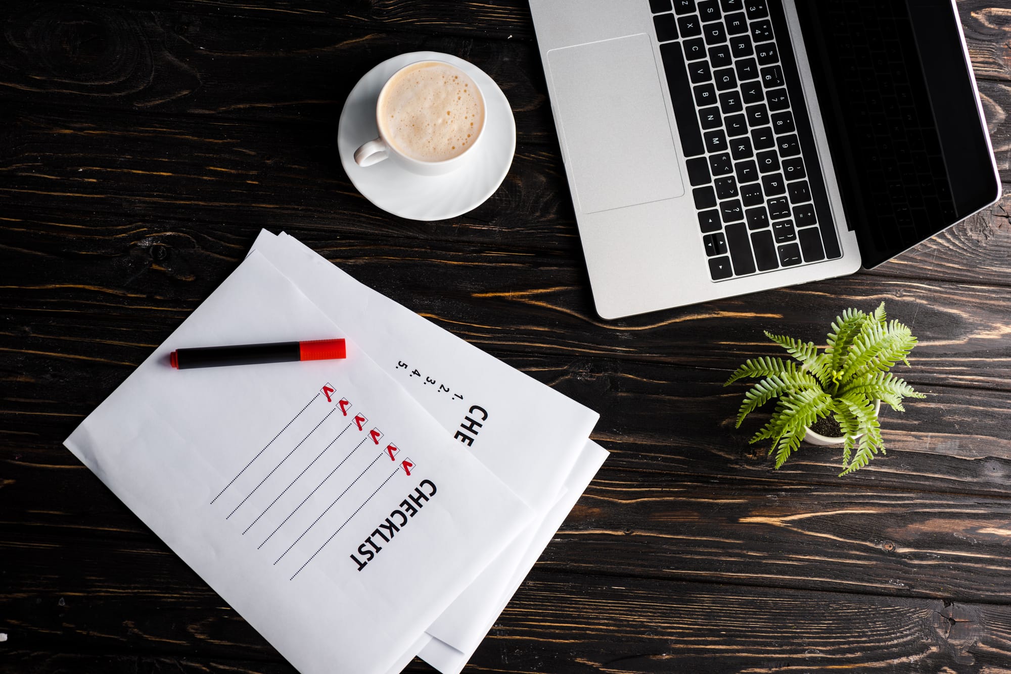 Laptop, coffee and checklist on desk