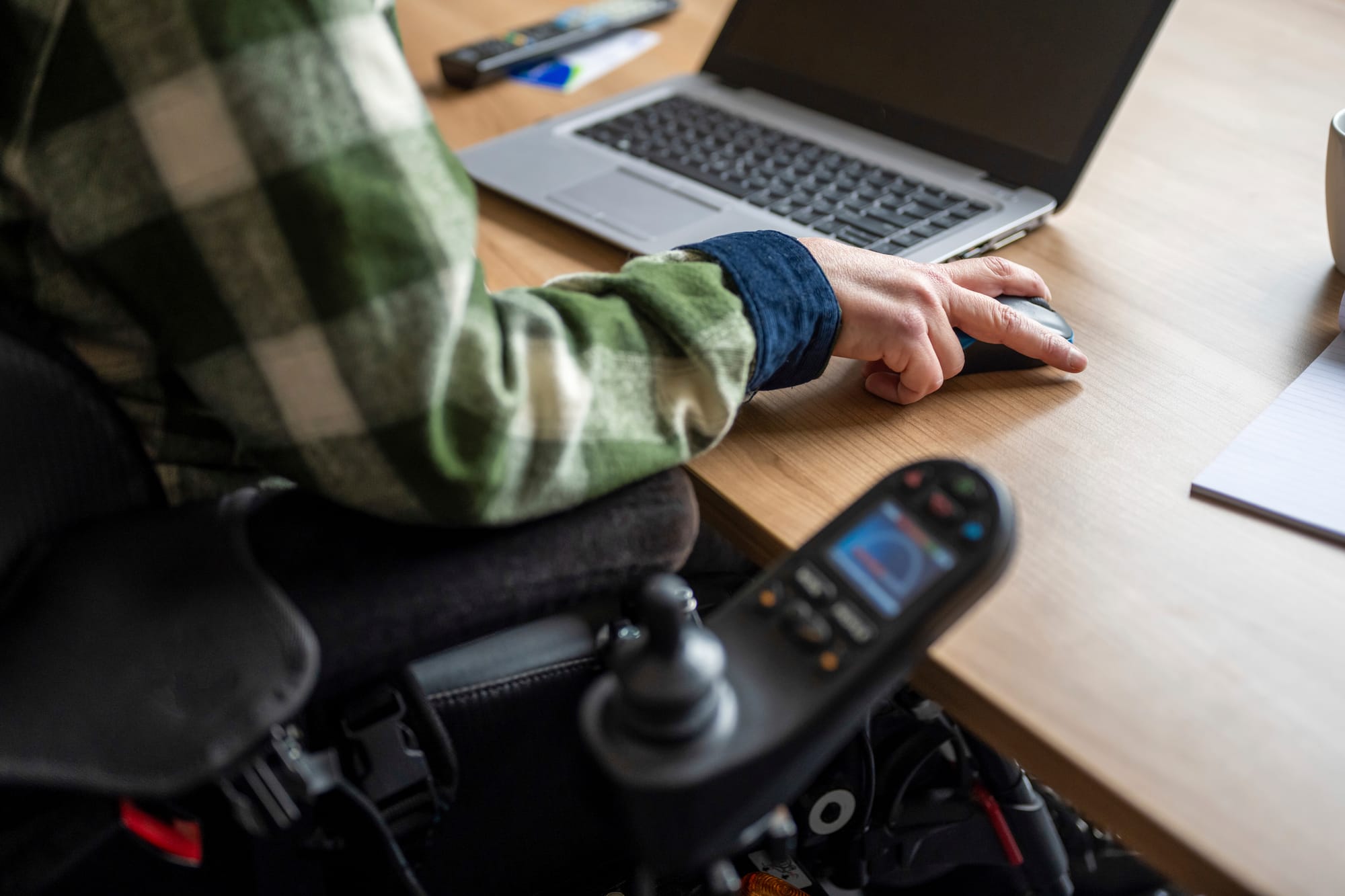 woman with painted nails using a laptop and a phone at the same time